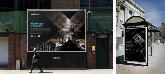 A bus station mockup of the keyvisual with the audix logo and the slogan 'hearing is believing'